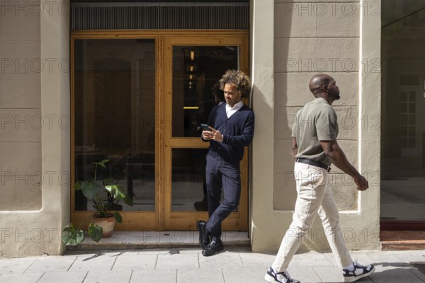 Professionals enjoying a sunny day outside a modern coworking space in Barcelona. The image
