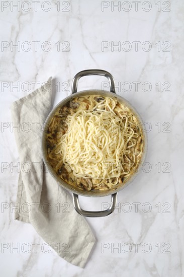 Overhead view of casserole with noodles and chopped champignon, chanterelles, oyster mushrooms and