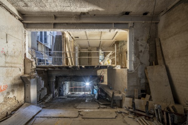 A construction site depicting an interior under renovation. Exposed beams, scaffolding, and
