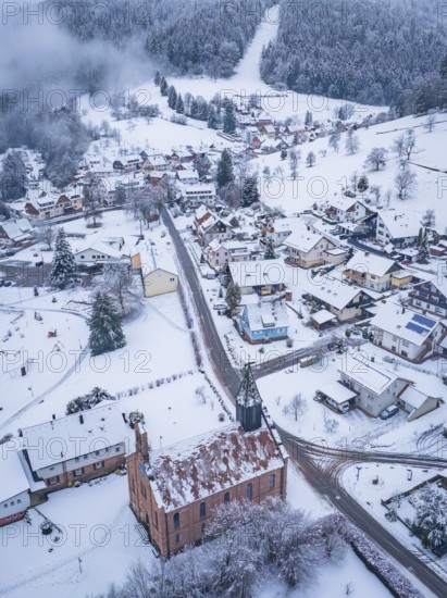 Snowy town view with church, surrounded by wooded hills, Enzklösterle, district of Calw, Black