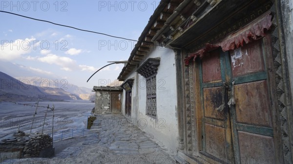 Traditional colorful wooden doors and stone walls with mountain views at dusk, trekking at