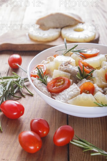 Chicken fillet salad with rosemary, pineapple and cherry tomatoes on brown wooden background. close