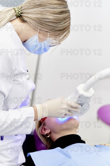 A dental professional in a clinic performing a specialized oral care procedure using modern