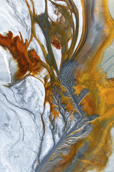 Intricate fractal patterns of vibrant mud textures create a stunning visual captured from above.
