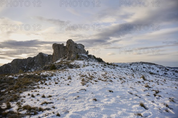 Stunning panoramic view of Montcabrer, Spain, showcasing a snow-covered mountain landscape at dusk,