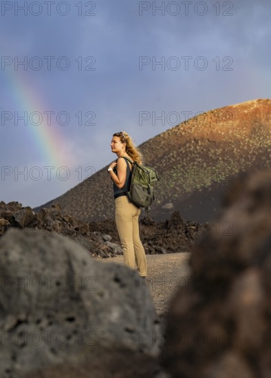 A woman with a backpack explores the volcanic landscape of Timanfaya National Park in Lanzarote. A
