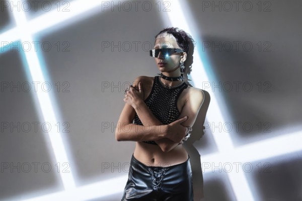 A woman embodies a cyberpunk aesthetic, wearing reflective sunglasses and a studded outfit. The