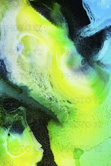 A dynamic abstract composition of swirling green, yellow, and blue inks. The vibrant textures and