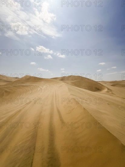 Sweeping views of Ica's vast sand dunes stretch under a vibrant blue sky, showcasing the unique