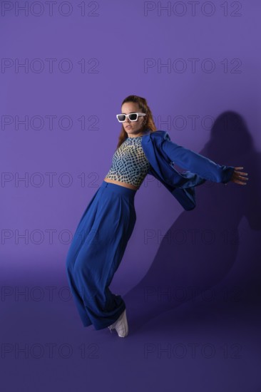 A young woman exudes grace and energy as she performs a dynamic dance against a striking purple