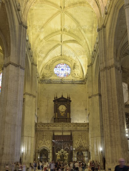 Gothic interior of a cathedral with high ceiling, stained glass window and organ, Seville,
