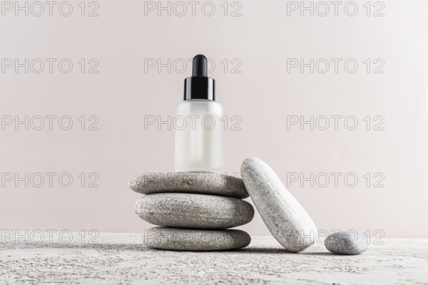 A minimalist skincare concept with a frosted glass dropper bottle placed elegantly on a stack of