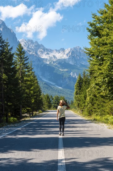 A young girl walking on the road in the Valbona valley, Theth national park, Albanian Alps, Valbona