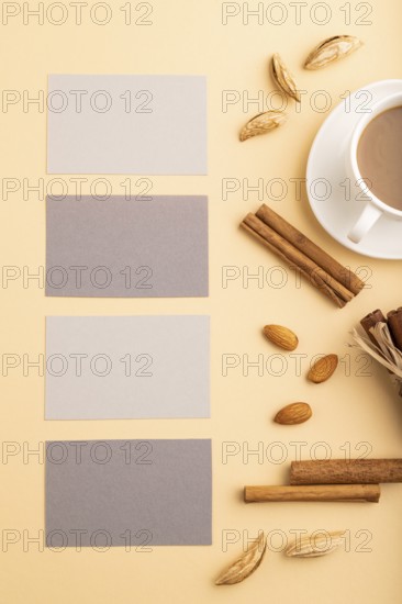 Composition of gray paper business cards, almonds, cinnamon and cup of coffee. mockup on orange
