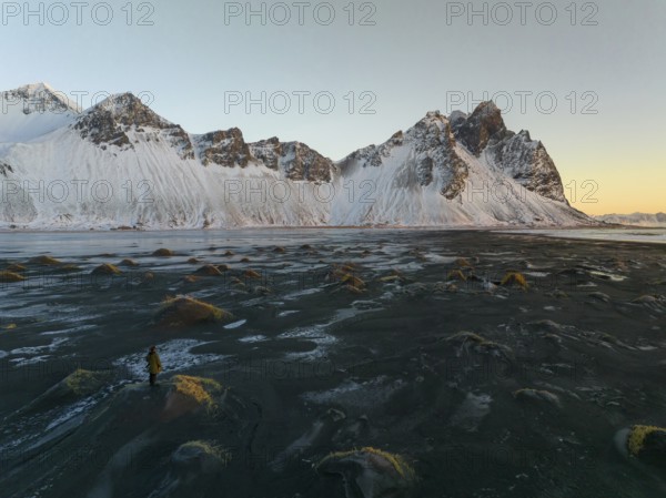 A stunning winter view of Stokksnes Beach in Iceland, featuring rugged snow-capped peaks against a