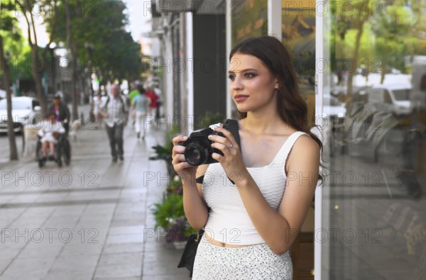 A young woman stands on a bustling city street, holding a camera She gazes ahead, ready to capture