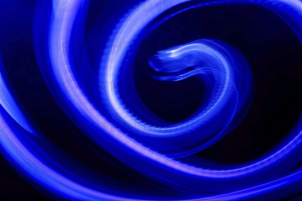 A mesmerizing abstract composition featuring swirling blue neon lights against a deep black