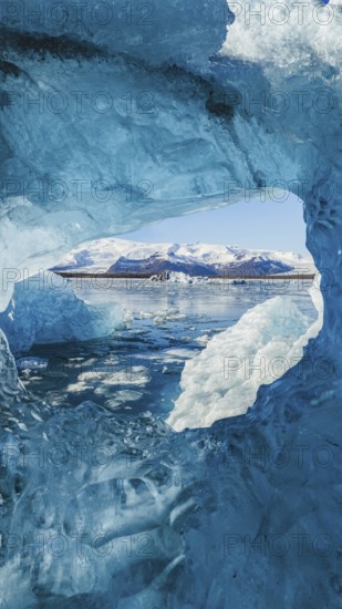 Stunning view from within a crystal-blue ice cave in Jokulsarlon, Iceland, framing the glacier