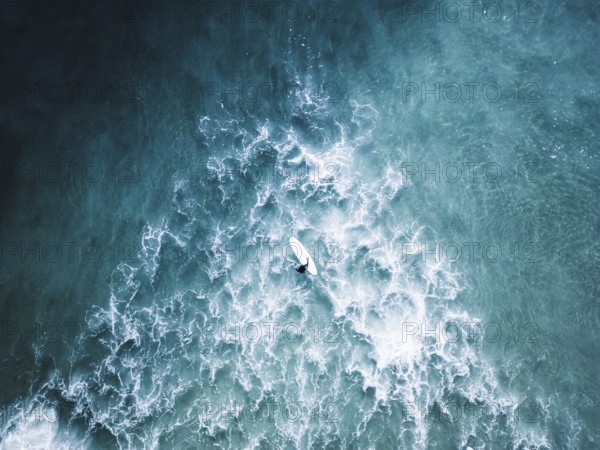 A stunning surf photo session in Portugal captures surfers navigating vibrant blue waves. The scene