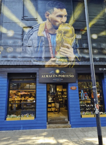 Shop front with a large mural of footballer Lionel Messi with trophy, La Boca neighbourhood, Buenos