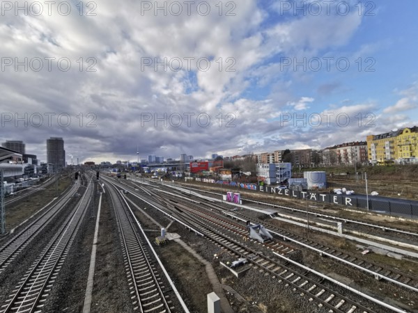 Panorma of urban rail infrastructure under a cloudy sky in summer with city in the background,