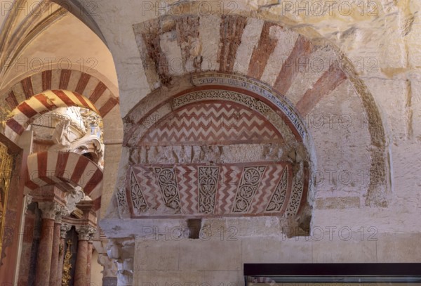 Detailed arched structure with red and white patterns on a stone wall, Cathedral Mosque of Córdoba