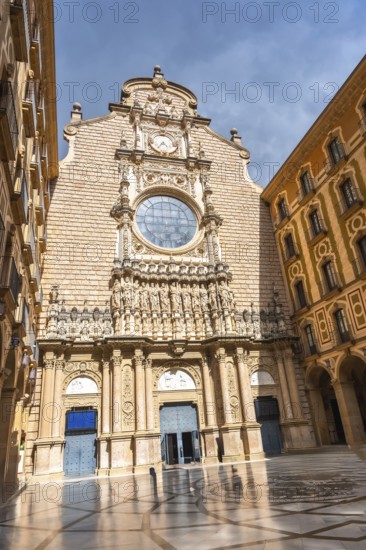 The imposing facade of the montserrat monastery, featuring intricate details and a large rose