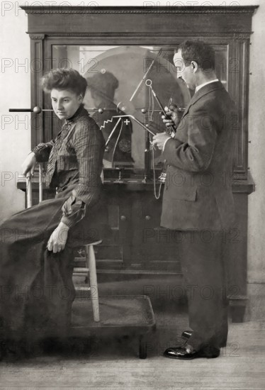 A patient being treated by Proffessor Wilhelm Conrad Röntgen with a direct spark treatment, an