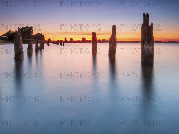 View at sunset over the Strelasund of the skyline of the city of Stralsund with its churches and