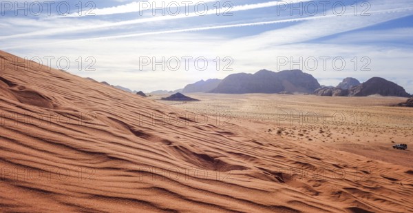 Captivating view over the red sand dunes in Wadi Rum Desert, Jordan, under a clear sky, with