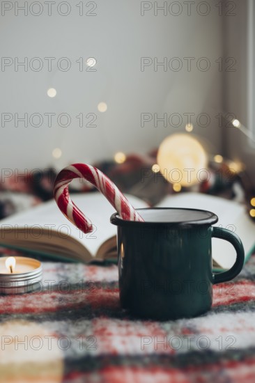 Cozy Christmas setting featuring a steaming mug and a candy cane resting on an open book,
