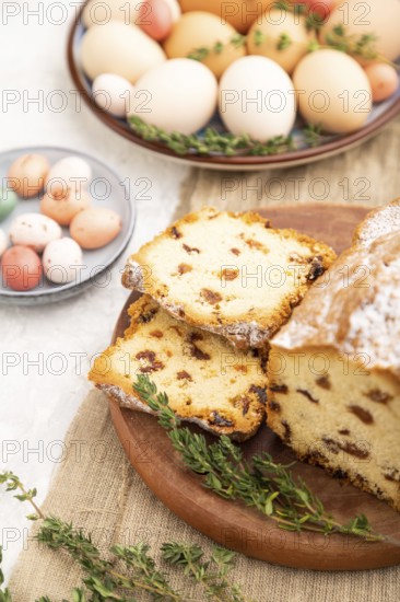 Homemade easter pie with raisins and eggs on plate on a gray concrete background and linen textile.