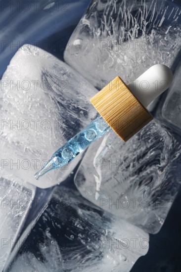 A rejuvenating face care serum or oil for men, presented in a stylish dropper bottle encased in ice