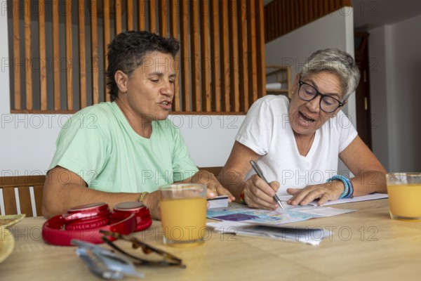 A lesbian couple is focused and active as they plan their summer holidays, marking details on