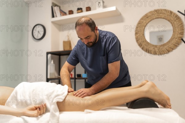 Masseuse working on a client's leg, providing deep tissue therapy for relaxation and muscle