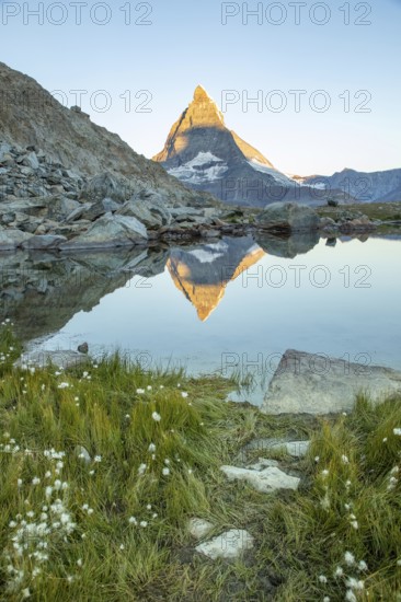 Serene landscape of the Matterhorn in the Swiss Alps, captured at dawn. The iconic peak reflects