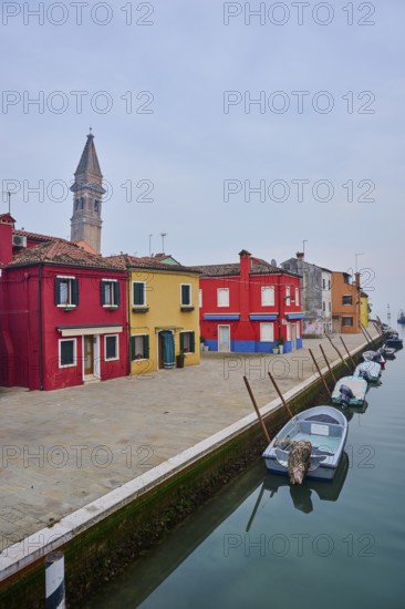 Colorful houses beside the waterway at 'Fondamenta di Pizzo' with boats lying in the water on the