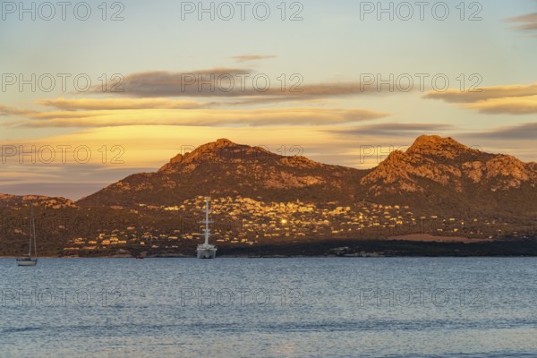 View of Lumio, sailing cruise ship Wind Spirit and the mountains at Calvi Bay, Balagne, Corsica,