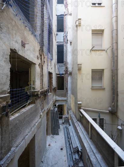 A detailed view of an urban renovation project, with exposed walls, construction materials, and