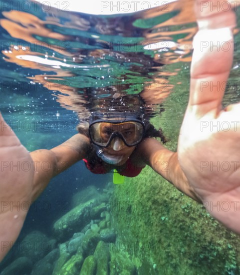 A snorkeler is captured half submerged in the clear waters of Tindaya Beach on Fuerteventura