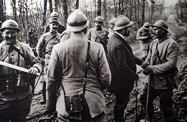 World War I. On the Argonne front, a soldier giving M. Barthou a bouquet of primroses