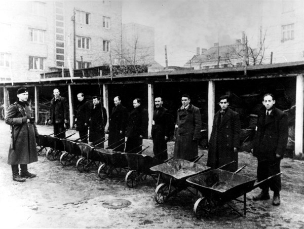 Workers in a camp, under a German soldier's supervision