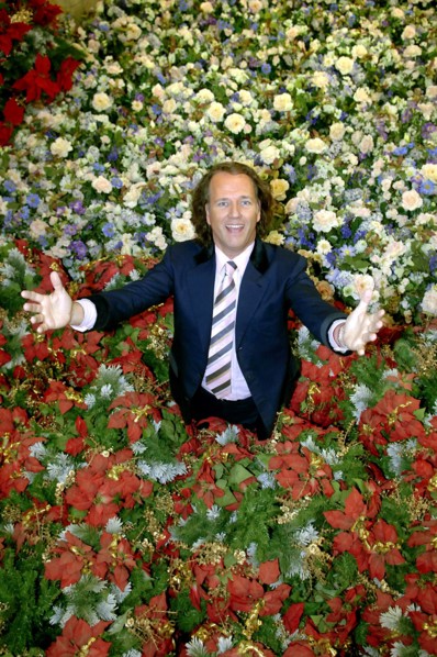 (dpa) - Dutch star violinist Andre Rieu smiles while standing in a sea of artificial flowers in