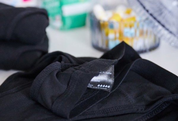 The label of period underwear symbolically depicts five drops for strong absorbency. (posed scene)