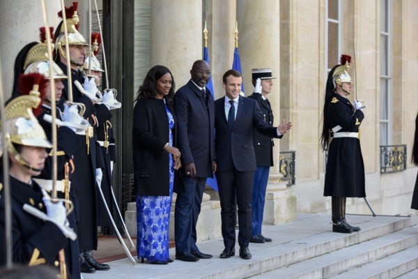 French President Emmanuel Macron and the newly elected visiting Leberian President George Weah pose for photos at Elysee Palace in Paris, France on Feb. 21, 2018.