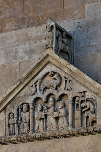 Fidenza, duomo (Cattedrale di San Donnino), portale sinistro, timpano. Nel frontone si leggono, da