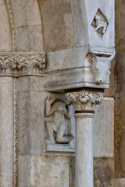 Fidenza, duomo (Cathedral of San Donnino), façade, left portal, prothyrum: telamon, capital and