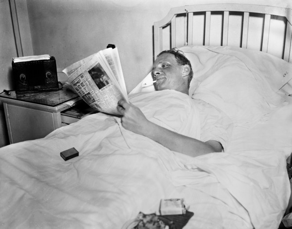 Man Smoking Cigarette while Reading Newspaper in Hospital Bed, Harris & Ewing, 1936