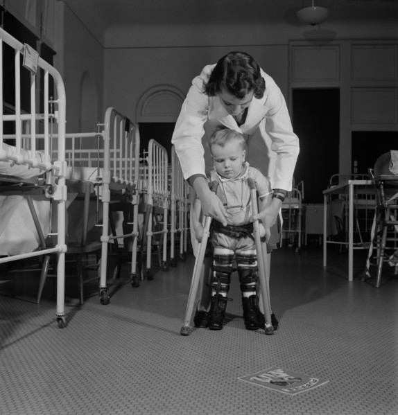 A student Nurse, Acting as Physical Therapist, Points to the Picture Book, Encouraging a Child to Learn to use his Crutches, Fritz Henle for Office of War Information, November 1942