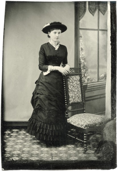 Portrait of Adult Woman in Hat and Long Dress Leaning on Chair Near Window, Tintype, circa 1870